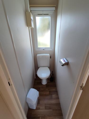 ein kleines Badezimmer mit Toilette und Fenster in der Unterkunft Smart Home Paris mit Terrasse, Europapark, Rulantica in Boofzheim