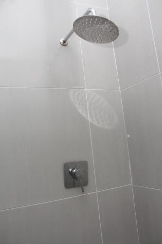 a shower with a shower head in a bathroom at The White House Lodge in Cape Town