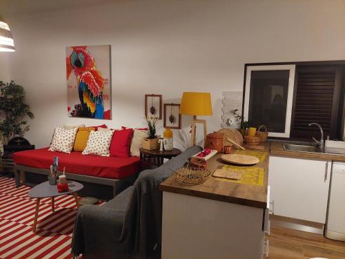 a living room with a red couch and a kitchen at ELEVEN -A- SUITE tipo T1 in Mértola