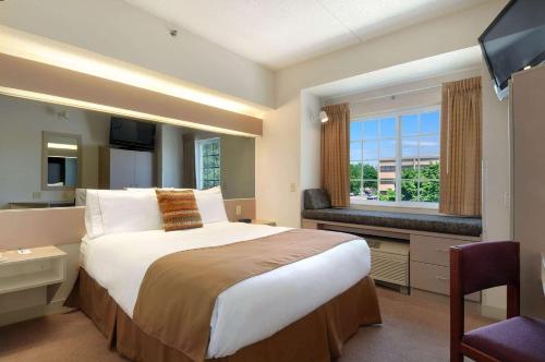 um quarto de hotel com uma cama grande e uma janela em Microtel Inn & Suites by Wyndham Bloomington MSP Airport em Bloomington