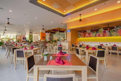 a restaurant with tables and chairs with pink napkins on them at Ramada by Wyndham Phuket Deevana in Patong Beach