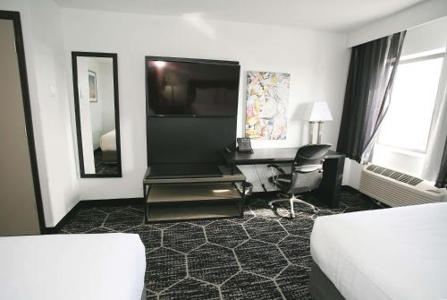 a hotel room with a desk and a television at La Quinta by Wyndham Des Moines West Clive in Clive