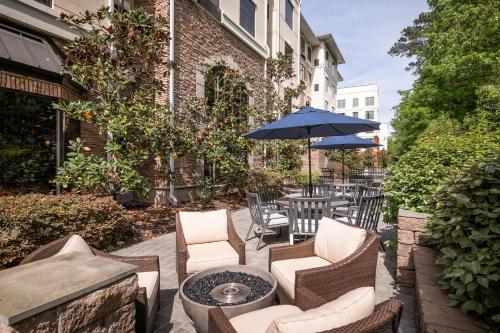 a patio with chairs and a table with an umbrella at Staybridge Suites North Charleston by IHG in Charleston