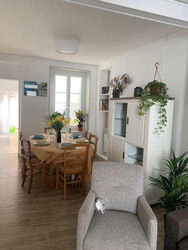 une salle à manger et un salon avec une table et des chaises dans l'établissement La Jonquille de St Vaast La Hougue, à Saint-Vaast-la-Hougue