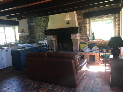a living room with a couch and a fireplace at Maison dans la prairie in Plurien
