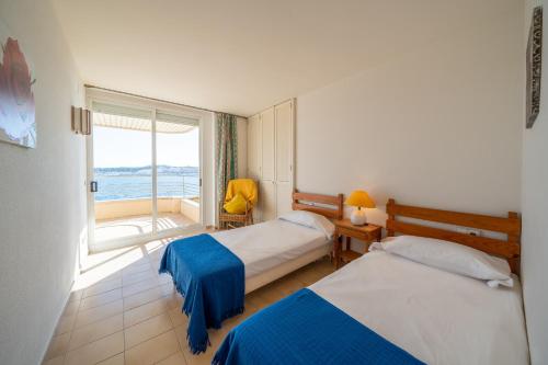 a hotel room with two beds and a window at Apartament Greta in L'Escala