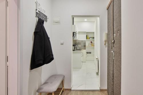 a small white hallway with a bench and a kitchen at Helen Homestay Žižkov in Prague