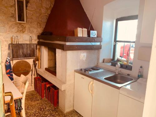 una cucina con fornelli e lavello di Old stone house VICKO a Podgora