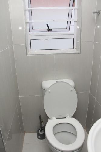 a bathroom with a white toilet and a window at The White House Lodge in Cape Town