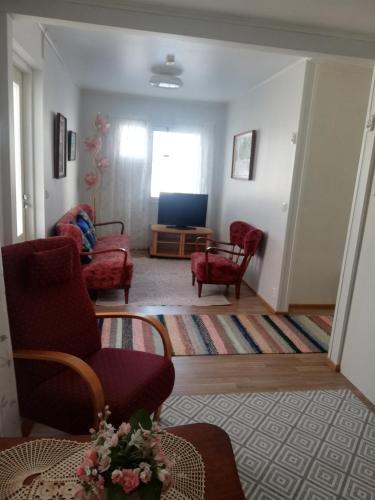 哈爾瑪的住宿－Huoneistomajoitus Hella Härmä，客厅配有两把椅子和一张沙发