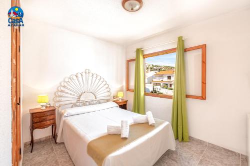 1 dormitorio con cama y ventana en Apartamentos Hibiscus Casa Azahar, en Alcossebre