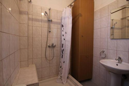 ein Bad mit einer Dusche und einem Waschbecken in der Unterkunft Melinas in Káto Alissós