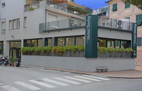 a building with a sign on the side of a street at Bike & Family Hotel Derby in Finale Ligure