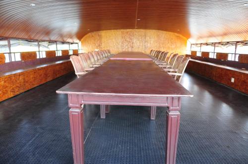 a long table and chairs in a room at Sreekrishna Houseboat in Kumarakom