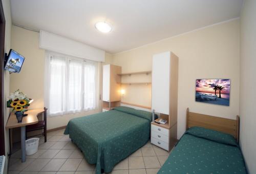 a hotel room with two beds and a window at Bike & Family Hotel Derby in Finale Ligure