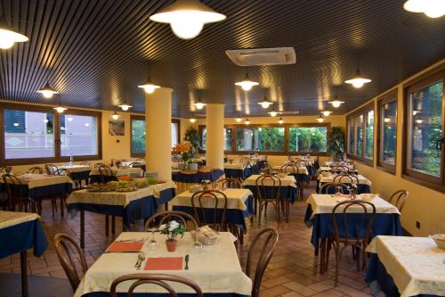 un comedor con mesas y sillas con mesas azules y blancas en Bike & Family Hotel Derby, en Finale Ligure