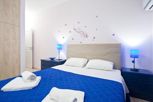 een slaapkamer met een blauw bed met 2 handdoeken erop bij Athina apartment Delphi in Delfoi