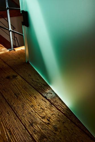 a room with a green wall and a wooden floor at Barokní kaplanka 1796 A. D. - luxusní apartmány v Českém ráji in Železný Brod