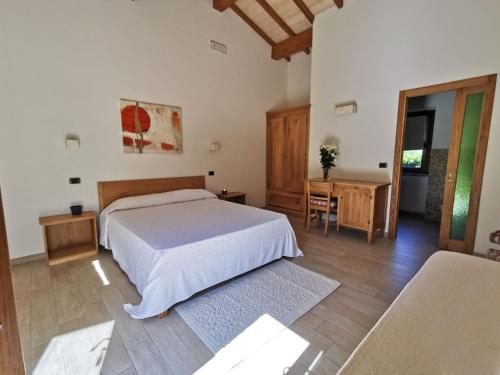 1 dormitorio con cama, mesa y escritorio en Agriturismo Le Fornaci - Camera Ginestra, en Mercatale