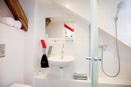 a bathroom with a shower, sink, and toilet at LH Vintage Design Hotel Sax in Prague