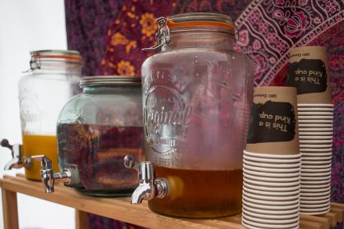 three jars of honey on a wooden shelf at Glamping at Hay Festival in Hay-on-Wye