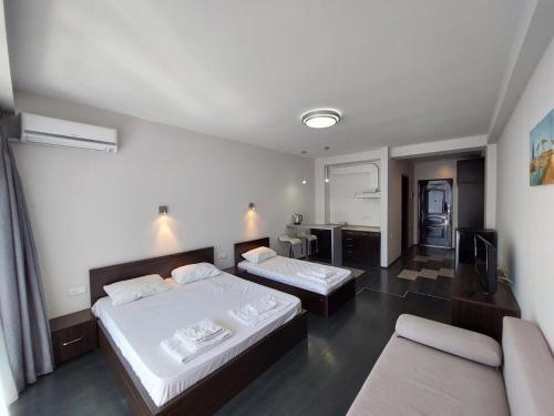ein Hotelzimmer mit zwei Betten und einem Fernseher in der Unterkunft Sunset kvariati in Kwariati