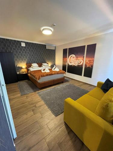 a bedroom with a large bed and a couch at Chicago Vendégház in Szentes