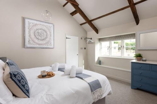 a bedroom with a white bed with a tray on it at Beach Cottage in St. Agnes