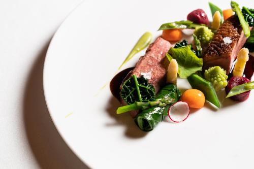 a white plate with a salad with meat and vegetables at Grand Hotel Majestic gia' Baglioni in Bologna