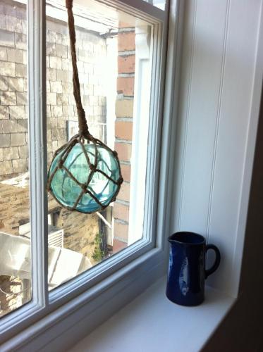 a window sill with a cup and a glass ornament at Harbour Retreat Padstow - Entire Apartment in the beautiful old town of Padstow Harbour in Padstow