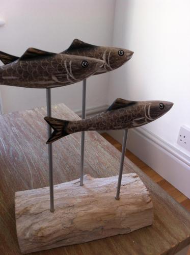 two fish on sticks on a wooden stand at Harbour Retreat Padstow - Entire Apartment in the beautiful old town of Padstow Harbour in Padstow