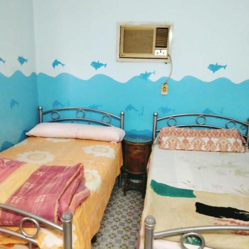 two beds in a room with bats on the wall at Elredy's apartments the blue edition in Cairo