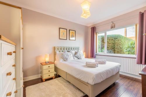 a bedroom with a bed and a window at Applegarth House - Norfolk Holiday Properties in Norwich