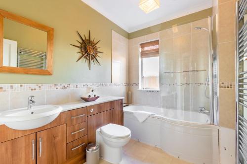 a bathroom with a sink toilet and a shower at Applegarth House - Norfolk Holiday Properties in Norwich