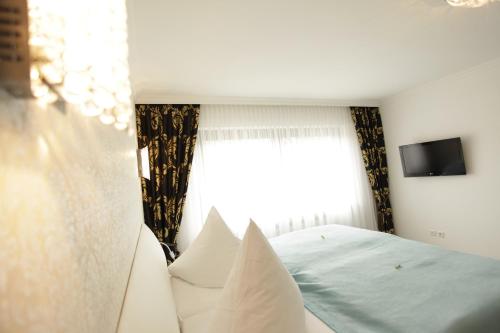 a bedroom with a bed with pillows and a window at Hotel Wulff in Bad Sassendorf