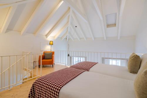 a bedroom with a bed and a chair in a room at YOUROPO - Taipas in Porto