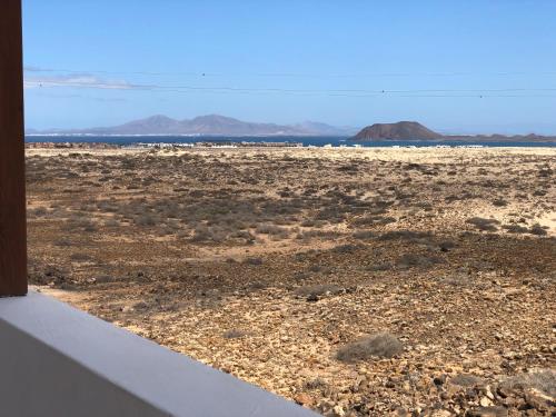 een uitzicht op een woestijn met de oceaan op de achtergrond bij VILLA MARIE Agradable y tranquila MAISON con piscina in Corralejo