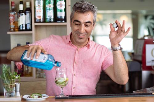a man pouring white wine into a glass at Oasis Scaleta Hotel in Skaleta