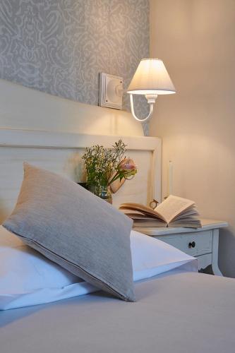 a bed with a pillow and a table with a lamp at Hotel Villa Aurora in Lezzeno