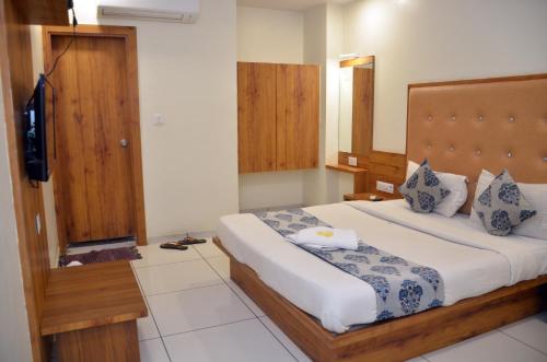 a bedroom with a large bed and a television at Hotel Neelkamal in Anand