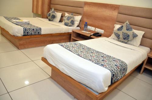 a hotel room with two beds in a room at Hotel Neelkamal in Anand