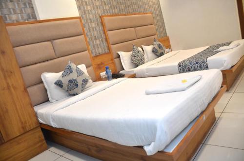two beds in a hotel room next to each other at Hotel Neelkamal in Anand