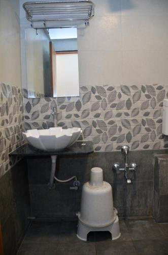 a bathroom with a sink and a mirror at Hotel Neelkamal in Anand