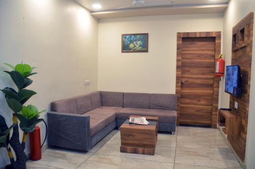 a living room with a couch and a table at Hotel Neelkamal in Anand