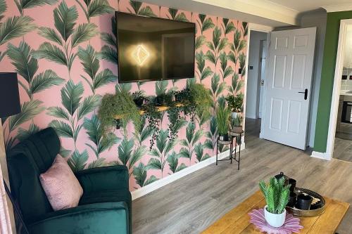 uma sala de estar com uma parede rosa e um espelho grande em The Marine - Balcony - Beach View - Coorie Doon Apartments em Ayr