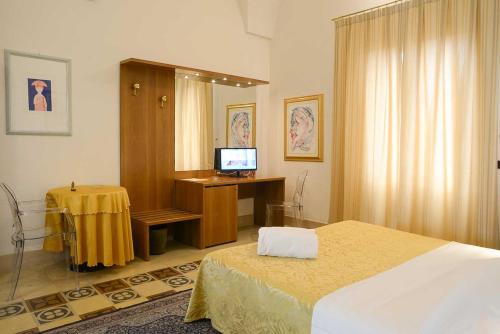 a bedroom with a bed and a desk with a computer at Albergo Italia in Matera