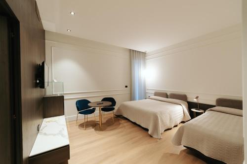 a hotel room with a bed and a table and chairs at Albergo Italia in Matera