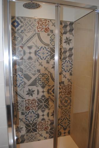 a shower in a bathroom with a tile wall at RAGGIO DI SOLE - pool, tennis, parking, sea view & relax in Rapallo