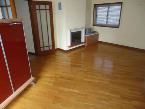 a living room with a wooden floor and a tv at Portugal Beach Point in Vila Nova de Gaia