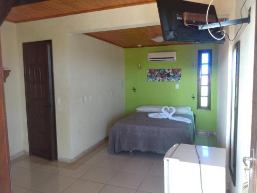 a bedroom with a bed and a tv in a room at Hotel Pousada Viking in Jacumã